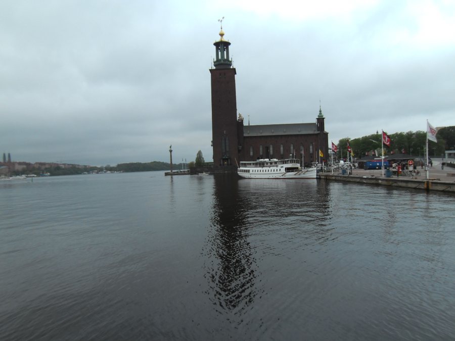 Stockholmer Rathaus am Wasser mit angelegtem Ausflugsschiff